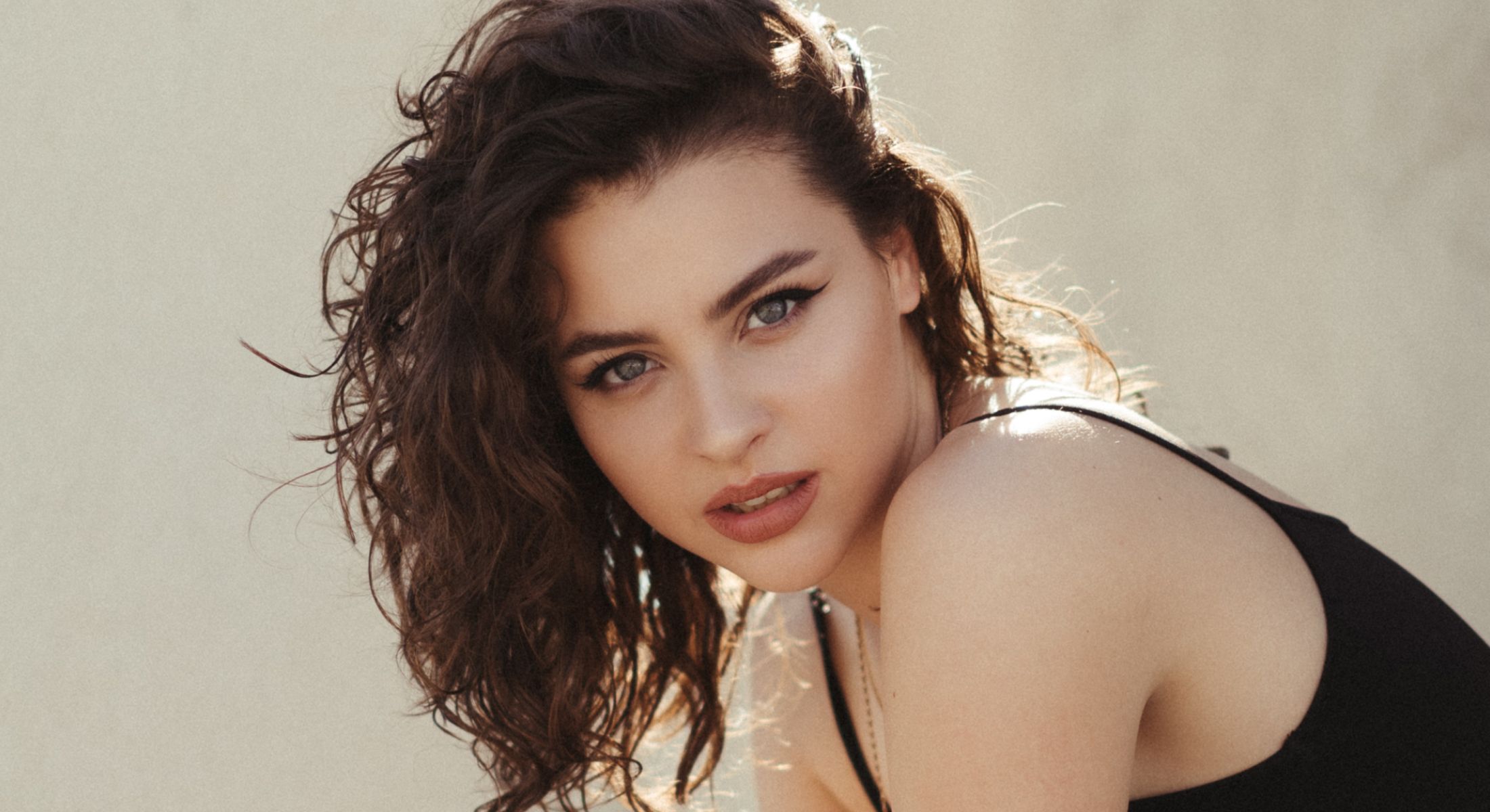 Woman with curly hair looking directly at camera.